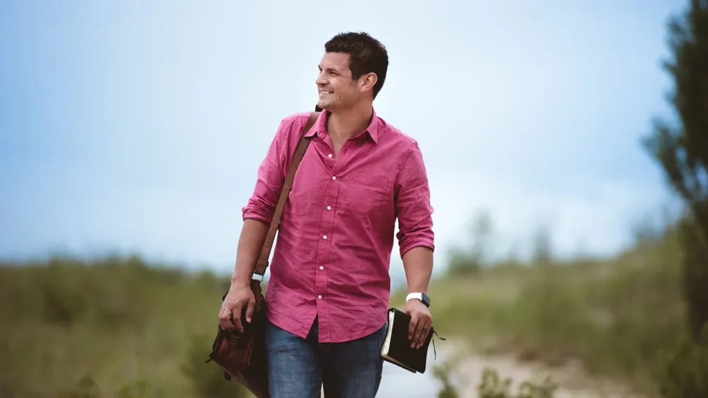 Man Carrying Bag and Book